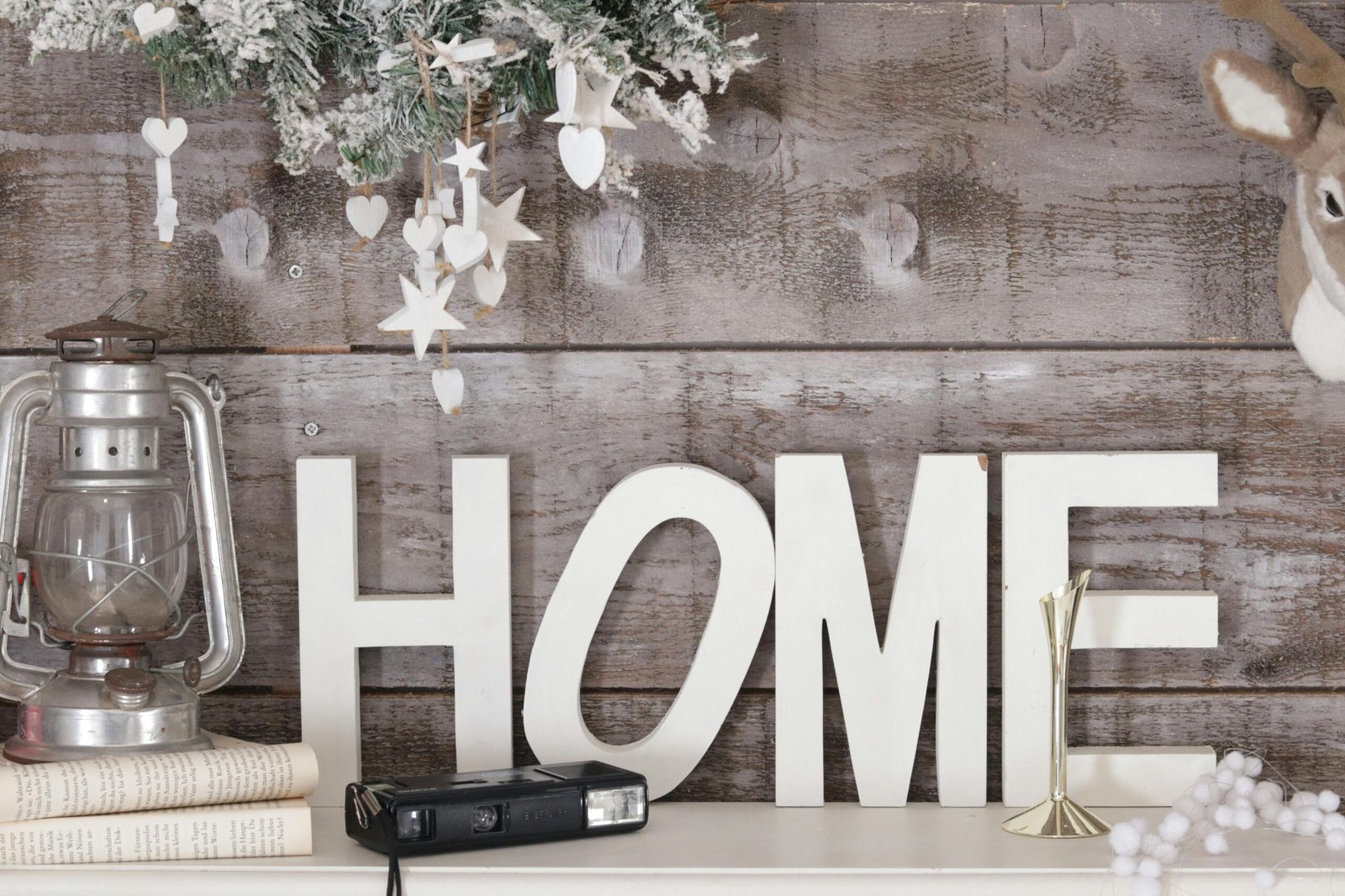 Warm and rustic home decor featuring a vintage lantern, wooden letters, and festive decorations.