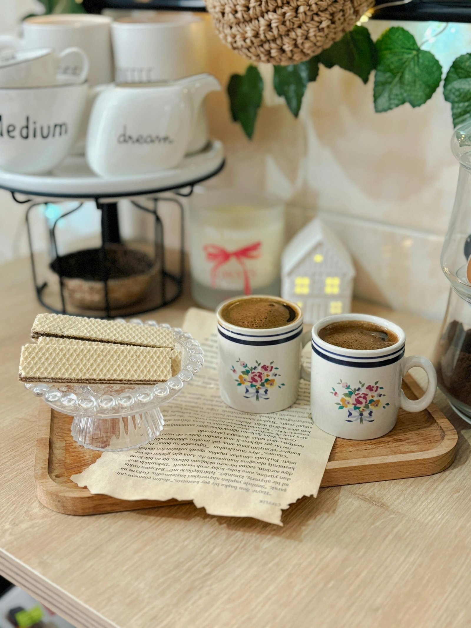 Warm and inviting coffee scene with floral mugs, wafers, and decor.